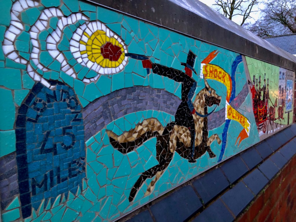 a bright mosaic with turquoise bands and a grey snaking road depicted. There is a mile stone saying London 45 miles and a man in black wearing a top hat on a horse. He is firing a gun which is depicted as a bright flash of red, yellow and white mosaic pieces. A banner is depicted in yellow with red writing saying Shock Oliver. 