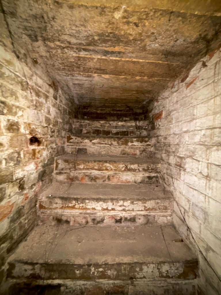 A close up of the steps which are made of brick disappearing into the ceiling above. 