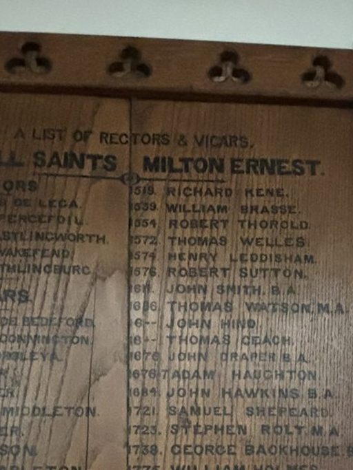 A wooden plaque with lists of names carved into it on the right hand side 6th from the top is written 1576 Robert Sutton.