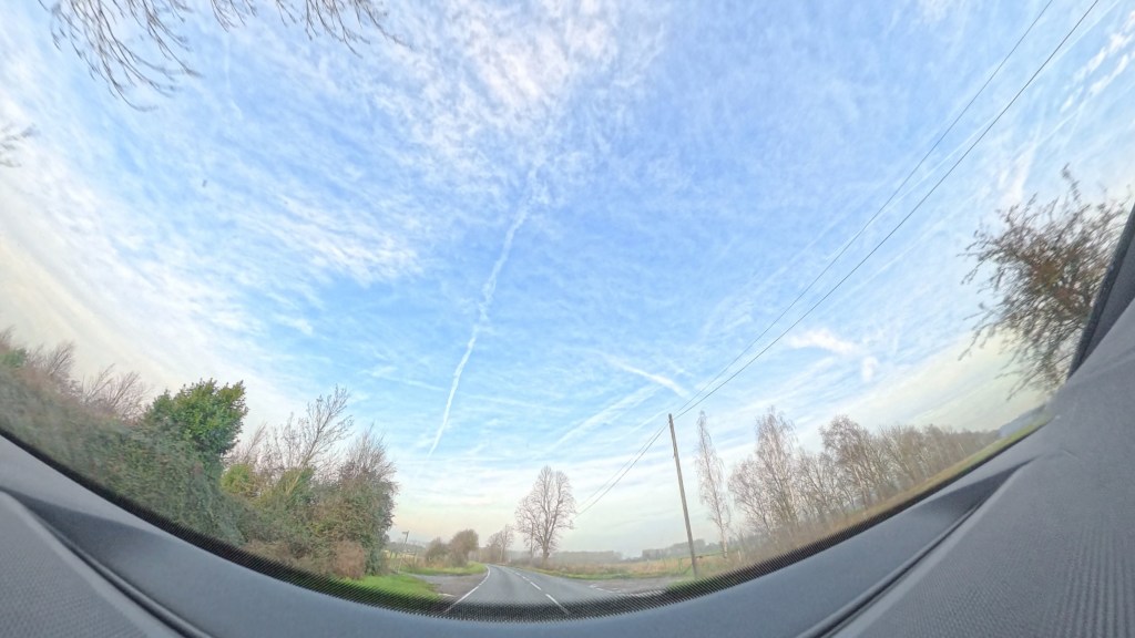 The road gently curving and winter trees wither side