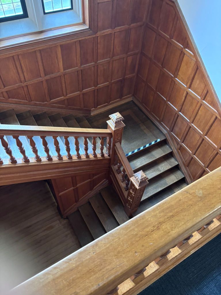 Looking down the curving wooden staircase within the hall. 